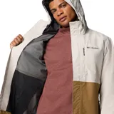 Campera impermeable Columbia modelo Hikebound II Jacket, con diseño en bloques de color beige en la parte superior y marrón claro en la inferior. Cuenta con capucha ajustable, cierre frontal, bolsillos con cremallera y tecnología Omni-Tech.