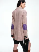 Blazer de corte recto con estampado de cuadros en tonos rosados, presenta bordados florales coloridos en el frente y un parche estilo escudo en el bolsillo superior. Cuenta con cierre frontal de botones y detalles en contraste en las mangas.