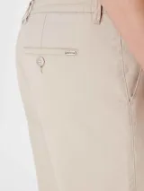 Bermuda de gabardina color beige con cintura elástica y cordón ajustable. Presenta bolsillos laterales y ruedo con dobladillo.