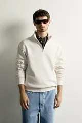 Sudadera negra de corte regular fit, con cuello subido, cierre frontal de cremallera corta y acabados en rib elástico en puños y cintura.