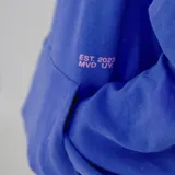 Canguro color marrón con efecto gastado, capucha y bolsillo delantero tipo canguro. Estampado pequeño con la palabra "Pulau" en el pecho.