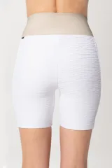 Calza corta deportiva blanca con paneles laterales en color beige.
