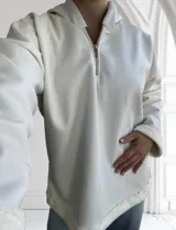 Buzo blanco de ecocuero con capucha, cierre dorado a mitad del frente y puños con forro de piel sintética.