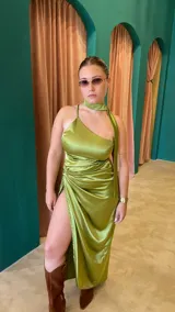 Vestido largo de satén color verde pistacho, con escote asimétrico, un tirante fino y cuello choker. Presenta abertura lateral en la falda y detalle drapeado en la cintura.