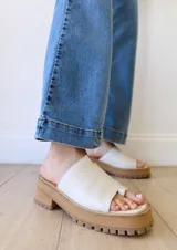 Sandalias de cuero crudo con tira ancha sobre los dedos y suela track color caramelo.