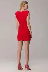 Vestido corto de jersey color rojo, con escote en V profundo, hombreras marcadas y diseño completamente drapeado en el cuerpo.