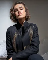 Tapado negro de paño de lana con corte recto, bolsillos laterales y estampado serigráfico de ventanas en color cobre.