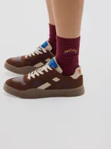 Sneaker Club 82 de cuero, color negro con detalles en beige y suela marrón. Cuenta con cordones off-white y una altura de suela de 3 cm.