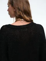 Sweater de punto con brillo, de corte relajado y escote en V. Presenta hombros caídos y mangas largas con puños acanalados.