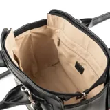 Cartera de mano estilo tote, confeccionada en símil cuero color negro con textura granulada. Presenta doble asa superior, correa larga ajustable y desmontable, y herrajes plateados. Incluye cierre principal y logo metálico de la marca en el frente.