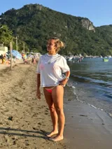 Remera blanca de corte boxy con costuras en color contrastante (posiblemente gris o azul oscuro) y un bordado pequeño en el frente con forma de estrella o flor.