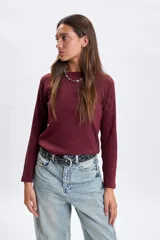 Remera de manga larga confeccionada en tejido rib, con cuello redondo y ajuste al cuerpo.