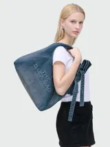 Cartera tipo hobo de Marc Jacobs modelo The Sack Bag, confeccionada en denim azul con el logotipo estampado en contraste en el frente.