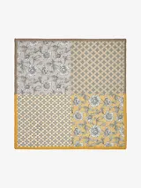 Pañuelo cuadrado con diseño de patchwork que combina cuatro estampados diferentes: floral en tonos grises y beige, y geométrico en tonos dorados y blancos.
