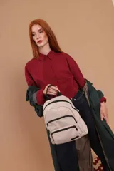 Mochila urbana de diseño funcional, color negro, confeccionada en nylon impermeable. Cuenta con un compartimento principal amplio, un bolsillo frontal adicional con cierre y correas ajustables con detalle de marca.