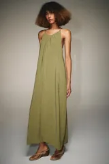 Vestido midi de corte recto y fluido, con cuello redondo y tirantes finos que se ajustan en la espalda mediante una lazada.
