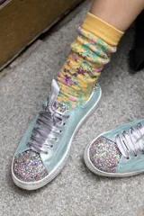 Championes celestes con glitter multicolor en punta y talón, lazo de raso y suela de cuero.