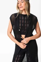 Chaleco largo sin mangas de tejido de punto negro, con trama artesanal calada y caída suave.