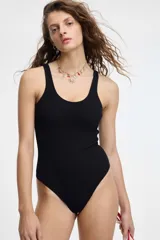 Malla enteriza de color negro, con escote redondo y tirantes anchos. Presenta un tejido acanalado.