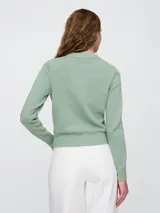 Buzo de algodón color crema, de corte recto y cuello alto.