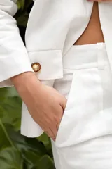 Blazer amarillo con solapas, corte entallado, cierre cruzado con botón y cinturón con hebilla redonda.