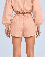 Short gris con cintura tipo clochard con regulador, ajustes con cordón en los laterales y bolsillos. Confeccionado en tejido ultra suave de poliéster y poliamida con protección UV 50+.