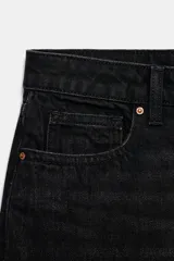 Jeans de mezclilla en color negro gastado, tiro bajo, corte de pernera recta y diseño clásico de cinco bolsillos con cierre frontal de cremallera y botón metálico.