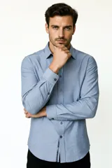 Camisa blanca de algodón, de diseño holgado y manga larga, con cuello camisero y cierre frontal de botones.