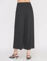 Pantalón palazzo de lino y viscosa, color blanco, de tiro alto y silueta amplia. Presenta pinzas frontales, bolsillos laterales y cierre con botón.