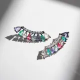 Par de aros plateados con forma de barra levemente curvada, con cristales engarzados en degrade de color pastel.