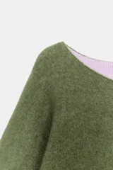 Jersey de punto de cuello redondo y manga larga con puños vueltos en contraste. Presenta un diseño holgado con aberturas laterales en el bajo.