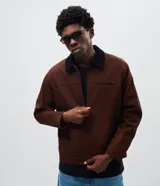 Campera masculina modelo trucker confeccionada en sarga de algodón. Presenta cuello de terciopelo en contraste, cierre frontal con cremallera, manga larga y bolsillo con cremallera en el pecho.