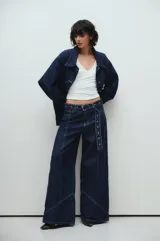 Jean de corte ancho confeccionado en denim azul oscuro con pespuntes a contratono y cinturón desmontable con ojalillos metálicos.