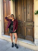 Minifalda negra de cuero sintético con volados y tachas plateadas.