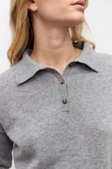Sweater de punto color gris, con cuello polo y cierre frontal parcial de botones, de manga larga y diseño holgado.