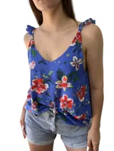 Blusa azul con estampado de flores rojas, blancas y amarillas, con breteles finos que se atan en los hombros.