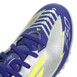 Championes de fútbol Adidas F50 Club TF J Messi para niños, color plateado con detalles en azul y amarillo.