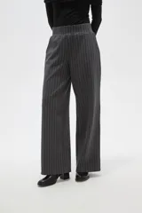 Pantalon de vestir de corte recto y tiro alto, confeccionado en tela de viscosa con diseño de rayas verticales finas en color blanco sobre fondo negro.
