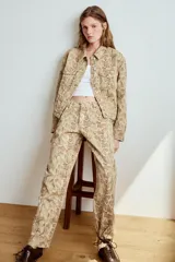 Jeans de tiro bajo con diseño de corte recto y estampado animal print de serpiente, con trabillas, cinco bolsillos y cierre frontal con cremallera y botón metálico.