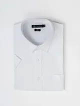 Camisa de manga corta blanca de algodón con efecto lino, cuello camisero, cierre frontal con botones y bolsillo ojal en el pecho.