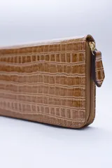 Billetera rectangular con cierre perimetral, confeccionada en cuero con textura de reptil. Cuenta con múltiples compartimentos internos para tarjetas, documentos y billetes, además de un bolsillo interior con cierre para monedas.