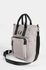 Mochila porta laptop negra de nylon, estilo urbano, con asas superiores para llevar en la mano, bolsillos frontales con cierre y etiqueta con logo impreso.