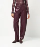 Pantalón de corte barrel confeccionado en poliuretano, con cintura alta, trabillas para cinturón, bolsillos funcionales y cierre frontal con botón y cremallera.