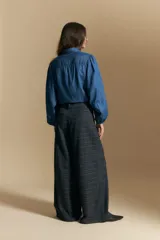 Pantalón de tiro alto con diseño a cuadros, corte wide leg y silueta amplia de caída fluida.
