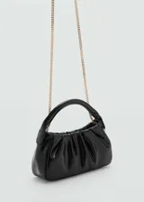 Bolso negro pequeño con diseño acolchado y doble asa corta.