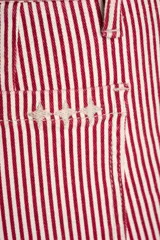 Pantalón de jean de corte recto, tiro medio, con estampado de rayas verticales color rojo y blanco.