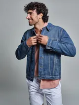 Campera de jean azul de corte regular, con lavado medio, dos bolsillos en la pechera con tapita y dos bolsillos inferiores.