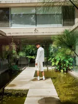 Camisa de lino con diseño de cuadrillé en tonos blanco y beige, de manga larga y cuello clásico. Presenta una pequeña estampa en el pecho y una estampa en la espalda, con un calce holgado y relajado.