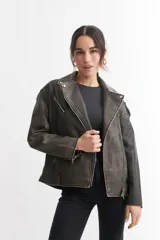 Campera tipo biker de cuero sintético color gris oscuro con efecto desgastado, cierre cruzado con cremallera, cuello con solapas y múltiples bolsillos con cremallera.