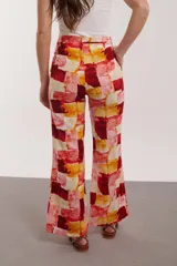 Pantalón de pierna ancha con estampado floral en tonos amarillo y gris, con cintura elastizada y cordón ajustable.